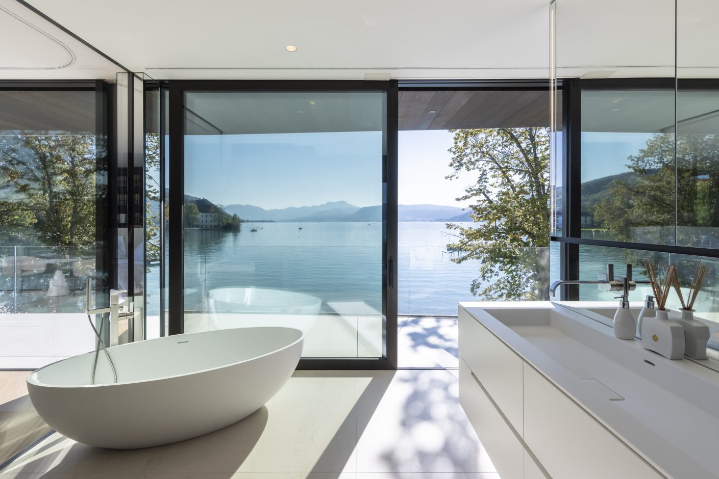 Auch das Bad im Obergeschoss ist mit einem Dekton-Boden im Farbton Danae ausgestattet und bietet eine malerische Aussicht auf das Schloss Kammer und die Alpen. © Urheber Schmid Baugruppe Holding GmbH, 2021