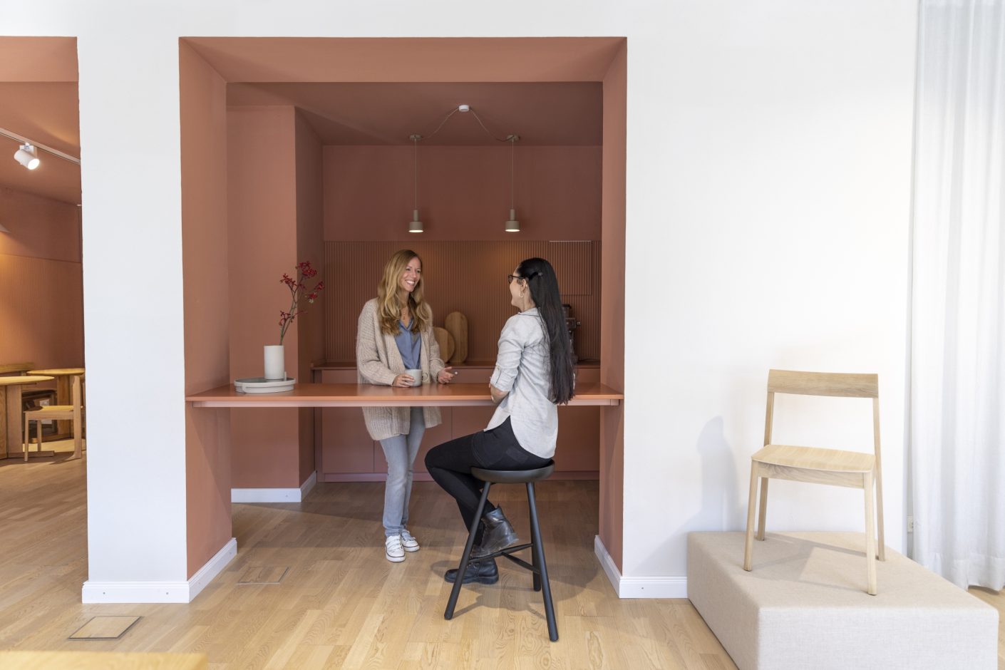 Hinter dem hellen Showroom mit nordischen Designmöbeln lädt das Mars-Café in erdigen Rot-Tönen zum Verweilen ein. Pictured by Betty Hofmann for Cosentino