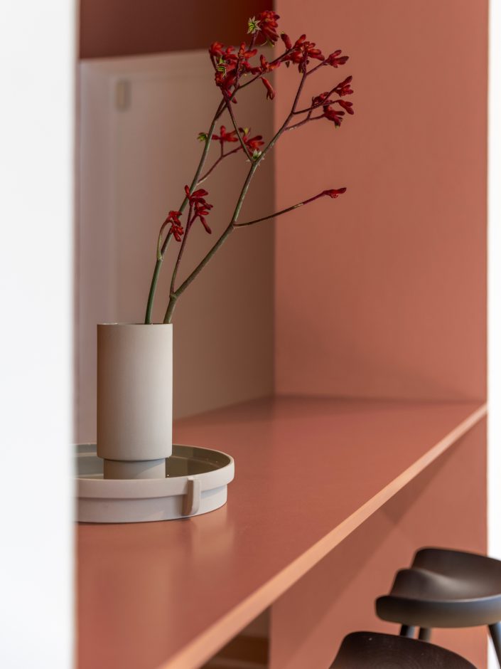 Küchenoberfläche und Theke bestehen aus Silestone im Farbton Arcilla Red. Die hybride Mineraloberfläche von Cosentino enthält mindestens 20 Prozent Recycling-Materialien wie Glas und wird klimaneutral mit 99 Prozent wiederaufbereitetem Wasser und 100 Prozent Strom aus erneuerbaren Quellen produziert. Pictured by Betty Hofmann for Cosentino