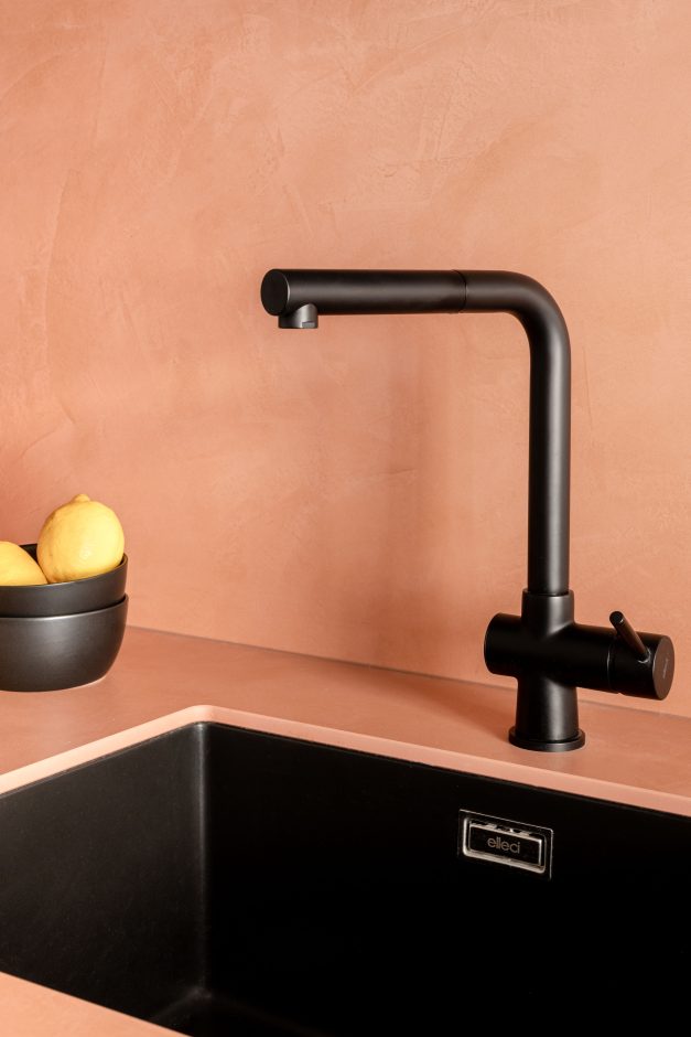 Elemente wie die schwarze Armatur und Unterbau-Spüle von Elleci setzen Akzente. Dekton® Umber ist durchgefärbt, was an den präzise angefasten Kanten gut sichtbar wird. Jede Platte wird kundenspezifisch zugeschnitten, bearbeitet und just-in-time von Cosentino angeliefert. Giulia Maretti Studio für YUGA Interiors