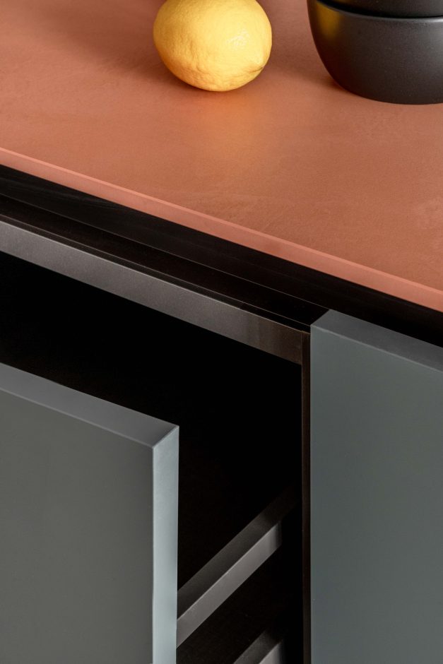 Elemente wie die schwarze Armatur und Unterbau-Spüle von Elleci setzen Akzente. Dekton® Umber ist durchgefärbt, was an den präzise angefasten Kanten gut sichtbar wird. Jede Platte wird kundenspezifisch zugeschnitten, bearbeitet und just-in-time von Cosentino angeliefert. Giulia Maretti Studio für YUGA Interiors